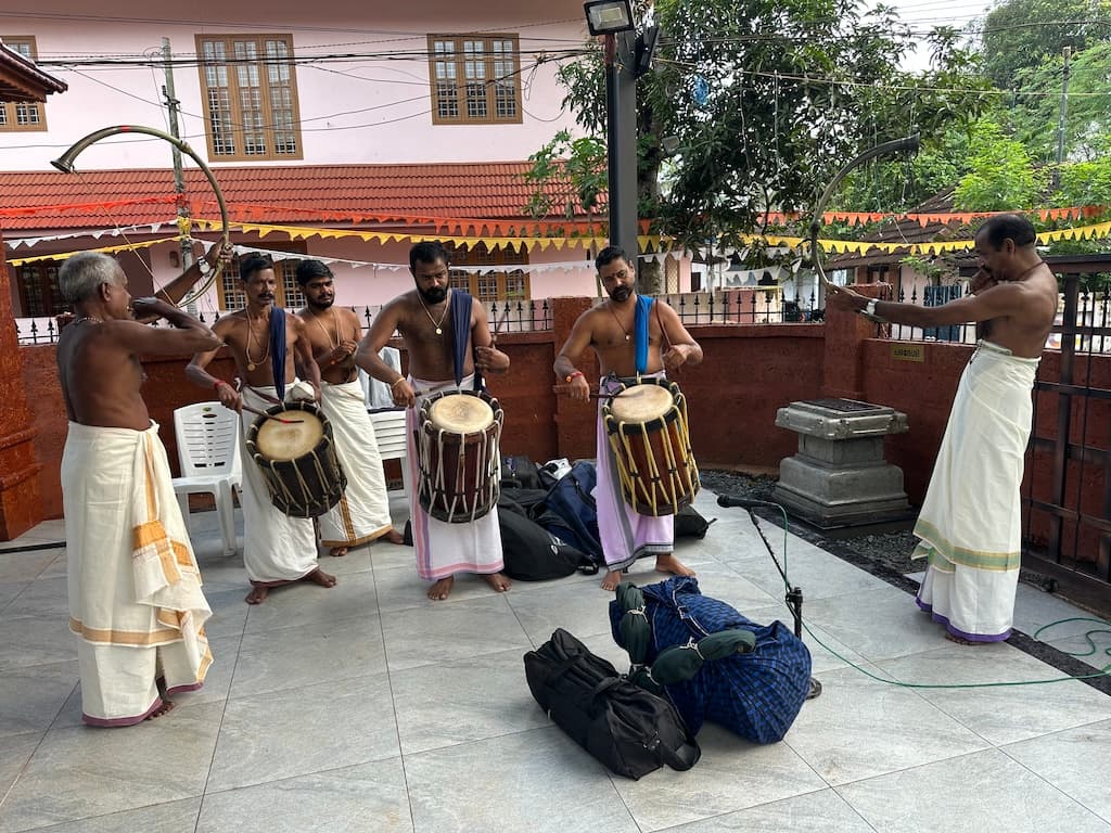 Chendamelam percussion ensemble performing in front of the temple.
