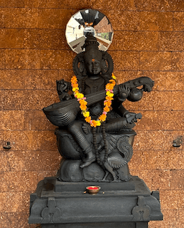 Saraswathi idol adorned in traditional attire.
