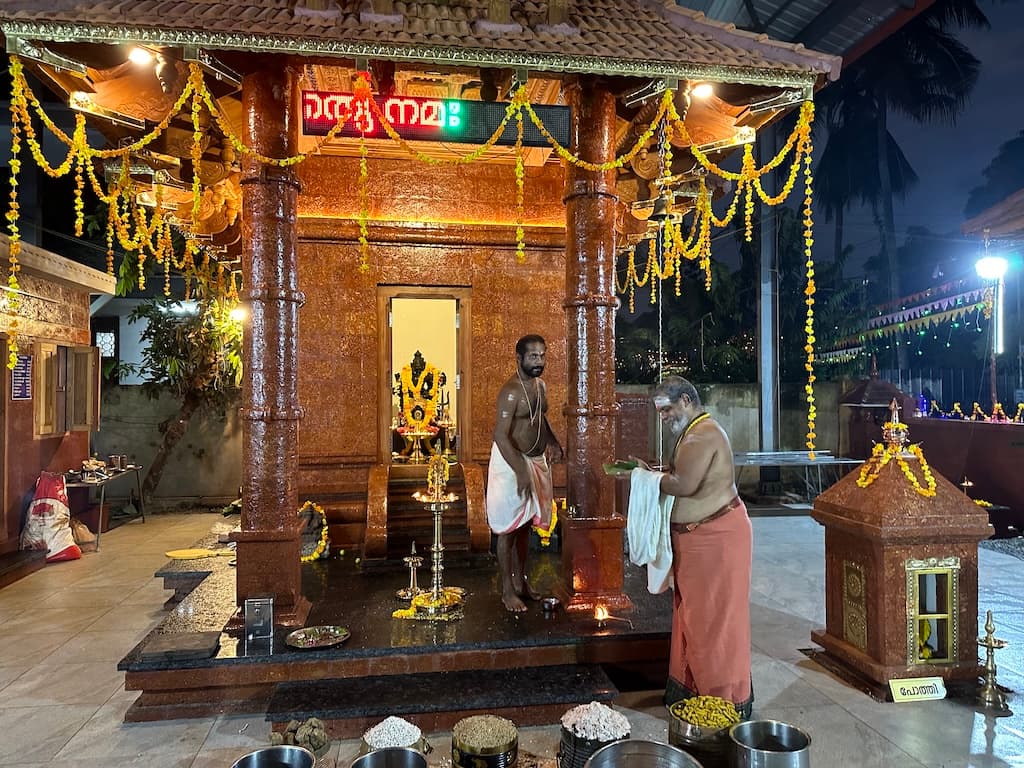 Devotees performing evening rituals at the temple courtyard.