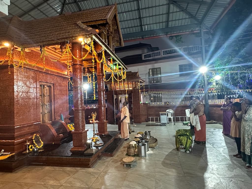 Night pooja with illuminated lamps around the sanctum.