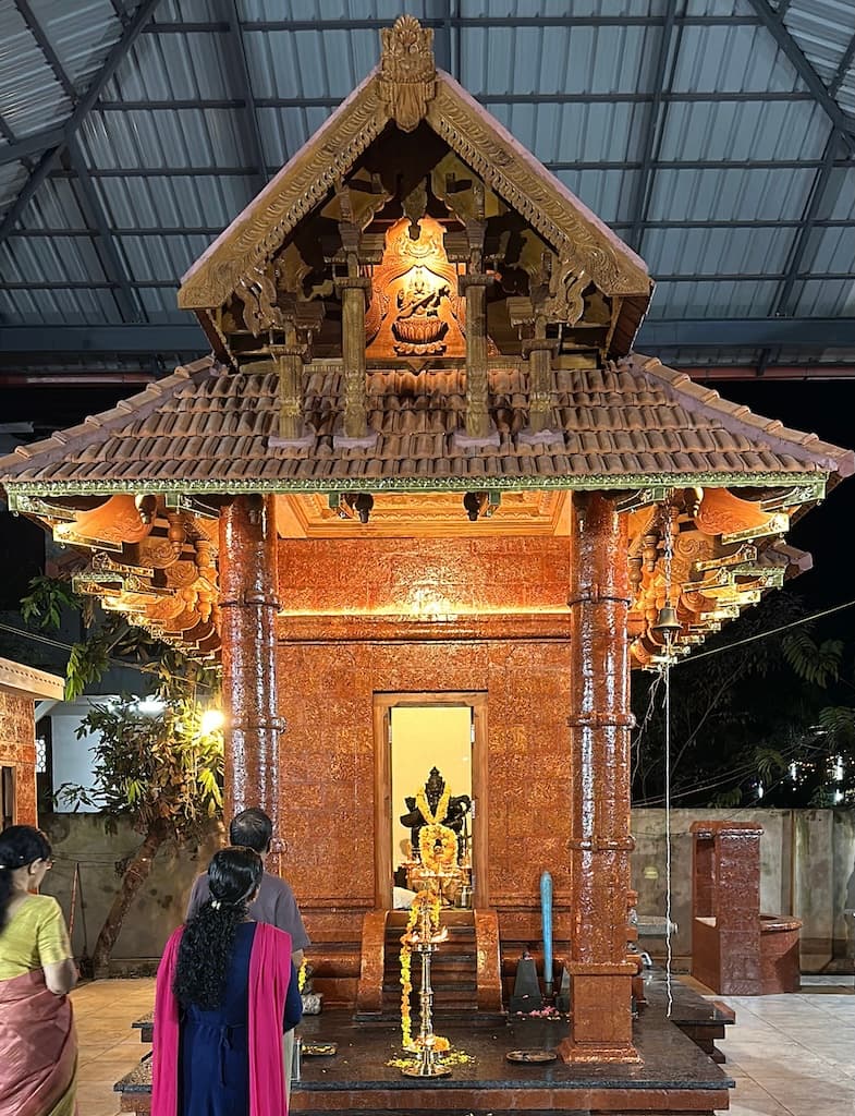 Temple entrance with devotees gathered for darshan.